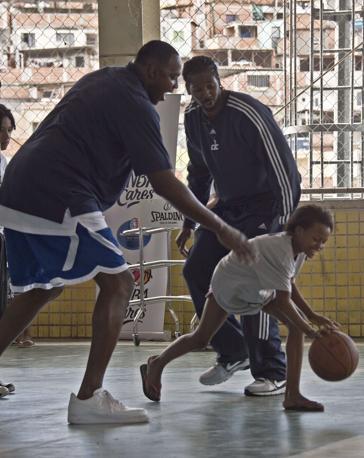 Horace Grant, ex cestista ora ambasciatore Nba,  e  Nene dei  danno qualche lezione di basket a una ragazzina. 